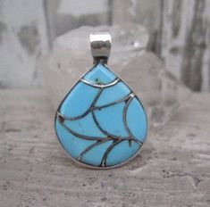 This pretty blue turquoise inlay pendant has a traditional Zuni fish scale pattern.  It is approximately 1 1/4" in length from the top of the bail to the bottom of the pendant.  It's smaller size and high shine polish gives this pendant a more contemporary feel while at the same time maintaining a Native American feel due to the traditional fish scale pattern.  Not stamped sterling though it tests as sterling.  Hallmarked ELB.  If you are not satisfied with your purchase please contact me and al Unique Blue Teardrop Turquoise Necklace, Artisan Blue Turquoise Teardrop Pendant Necklace, Traditional Blue Turquoise Necklace With Inlay, Traditional Blue Turquoise Necklace With Large Pendant, Blue Turquoise Inlay Necklace For Gift, Blue Turquoise Teardrop Necklace Nickel Free, Turquoise Inlay Necklace For A Gift, Nickel-free Blue Turquoise Teardrop Necklace, Blue Teardrop Turquoise Necklace Nickel Free