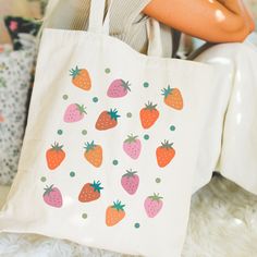 Introducing our irresistibly adorable Strawberry Tote Bag, a delightful blend of charm and functionality! Whether you're heading to the farmer's market, a picnic in the park, or simply running errands, this tote is your perfect companion. Crafted with care, our tote comes in two delightful colors: natural (tan) and sleek black, ensuring there's a style to suit every taste. The standout feature? Adorable strawberries adorned in various shades of pinks and reds, along with playful green polka dots Trendy Cheap Bags With Strawberry Print, Summer Strawberry Print Bag For Daily Use, Trendy Strawberry Print Bag At Affordable Price, Trendy Rectangular Bag With Strawberry Print, Cute Strawberry Print Tote Bag, Fruit Bag, M Craft, Edgy Aesthetic, Strawberry Fruit