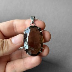 Smoky Quartz Pendant - Large Smoky Quartz Necklace - Quartz Pendant - Smoky Quartz Jewelry - Quartz - Sterling Silver and Smoky Quartz Gemstone: Natural Smoky Quartz Metal: 925 Sterling Silver Stone Cut: Faced Stone Size: 40.8 mm x 26.6 mm - 1.60 in x 1.04 in Pendant Size: 55.5 mm x 26.6 mm - 2.18 in x 1.04 in Weight: 25 grams (125 carats ) total weight of stone and metal.  For ring orders, ring resizing is free.  Chains are gifts for necklace orders..  Note: We don't use any filters for photos. The details may not be clear. Feel free to contact us with any questions, special orders or additional photo or video requests. We will be happy to provide more information! :) WORLDWIDE FedEx, UPS or TNT EXPRESS MAIL SERVICE (Delivery time: 1 - 5 business days.) LAYAWAY PAYMENT PLAN is available. Luxury Smoky Quartz Engagement Jewelry, Smoky Quartz Jewelry, Smoky Quartz Necklace, Smoky Quartz Pendant, Quartz Jewelry, Payment Plan, Quartz Pendant, Stone Cuts, Quartz Necklace