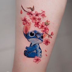 a tattoo with stitching on the leg of a woman's leg, featuring lili and cherry blossoms