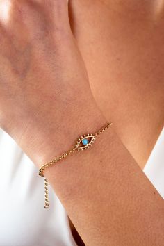 "This 14K gold evil eye bracelet is a stylish and delicate accessory that would make a great gift for any occasion. The bracelet features a rolo chain link design and is adorned with an evil eye charm, which is believed to protect against negative energy and bring good luck. The bracelet is dainty and would be a perfect choice for everyday wear. It would make a thoughtful gift for a friend or loved one, whether it be for a special occasion like Christmas, Father's Day, Mother's Day, Valentine's Gold Spiritual Evil Eye Bracelet With Adjustable Chain, Gold Symbolic Bracelet With Evil Eye, Symbolic Gold Bracelets With Evil Eye, Gold Bohemian Bracelet With Evil Eye, Gold Evil Eye Bracelet, Bracelet Evil Eye, Maid Of Honor Gift, Link Design, Bracelet Dainty