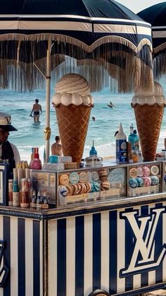 an ice cream stand on the beach with umbrellas