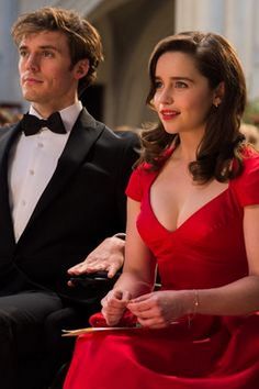 a woman in a red dress sitting next to a man in a tuxedo