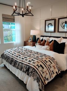 a bedroom with a bed, chandelier and pictures on the wall