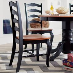 a dining room table with four chairs and a bowl of popcorn on the floor next to it