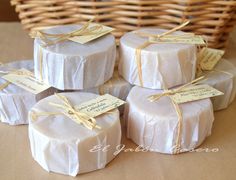 four wrapped gift boxes sitting on top of a table next to a wicker basket