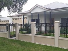 a white house with black iron fence and gate