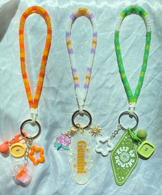 three lanyards with different designs and colors are on a white cloth background,