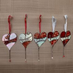 five heart shaped ornaments hanging on a wall