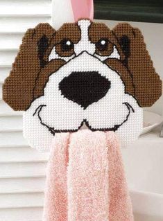 a brown and white dog is hanging from a towel