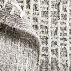 closeup of an area rug with white and gray patterns on the carpet, as seen from above