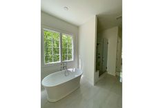 a large white bath tub sitting next to a window