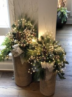 two vases filled with christmas trees and lights