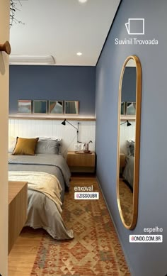 a bed room with a neatly made bed and a mirror