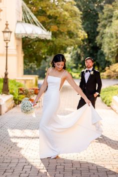 the bride and groom are walking down the sidewalk