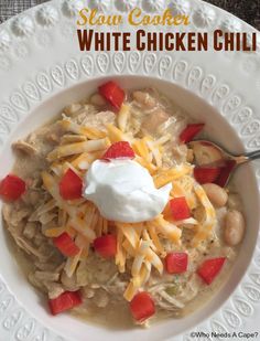 a bowl of slow cooker white chicken chili with sour cream and cheese on top