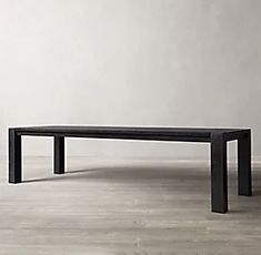 a black table sitting on top of a hard wood floor next to a white wall