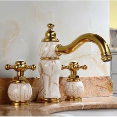 two golden faucets on marble counter top