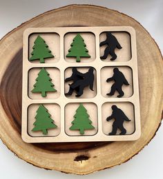 a wooden tray with black and green cutouts of different types of trees on it