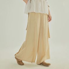 Inspired by Song Ku 宋裤 (Song Dynasty trousers), these wide legged pants are perfect for daily wear. Made of light and breezy fabric, these pants are lined within to ensure no flashes. Features the traditional waist tie but paired with a modern zipper closure. Triangular side pleats, creating the iconic flared shape. Wear as-is or under skirts! These fun pants can easily be styled with modern and traditional pieces. This item has a 7 day construction period. Materials: 82.6% viscose, 17.4% nylon Baggy Wide Leg Parachute Pants In Beige, Beige Wide Leg Parachute Pants With Relaxed Fit, Baggy Beige Wide Leg Parachute Pants, Baggy Wide Leg Beige Parachute Pants, Solid Color Wide Leg Parachute Pants For Spring, Beige Parachute Pants For Spring, Beige Baggy Wide-leg Parachute Pants, Beige Wide-leg Parachute Pants With Elastic Waistband, Beige Wide Leg Parachute Pants With Elastic Waistband