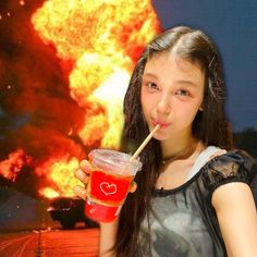 a girl holding a straw in front of an explosion