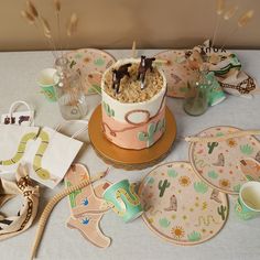 a table topped with plates and desserts covered in frosted cake next to utensils