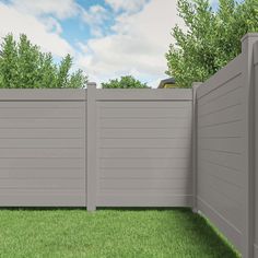 a gray fence in the middle of a green yard