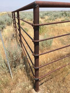 an old rusted metal fence in the middle of nowhere