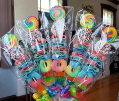 a vase filled with lots of candy and lollipops on top of a table