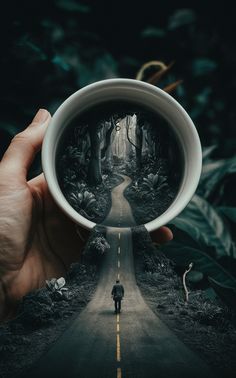 a person holding up a coffee cup with an image of a man walking down the road