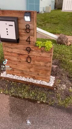 a wooden sign with numbers on it in the grass