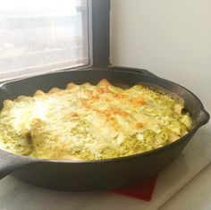 a casserole dish with cheese and broccoli in it on a counter