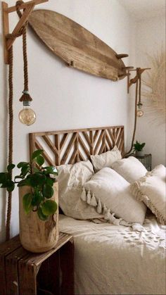 a wooden surfboard mounted to the side of a wall above a bed with pillows