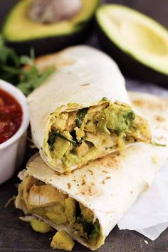 an avocado and chicken burrito with salsa on the side