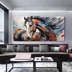 a living room filled with furniture and a large painting on the wall above it's coffee table