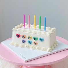 a birthday cake with candles on it sitting on a table