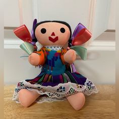 a stuffed doll sitting on top of a wooden table