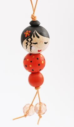 a wooden bead doll hanging from a string