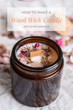 a jar filled with wood wick candle sitting on top of a table