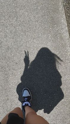 the shadow of a person's legs and shoes