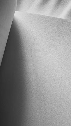 a sheet of white paper is laying on top of the bed sheets, with shadows coming from it