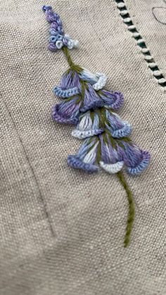 a close up of a piece of cloth with flowers on it and thread in the middle