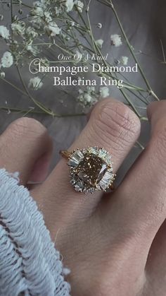 a close up of a person's hand with a diamond ring on their finger