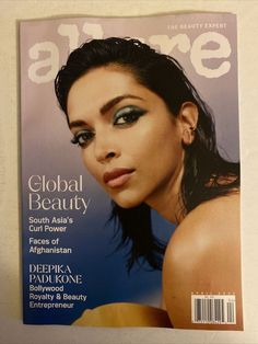 a magazine with an image of a woman's face on the front cover, and text that reads global beauty south asia's curl power