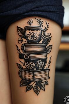 a woman's thigh with a stack of books and flowers on top of it