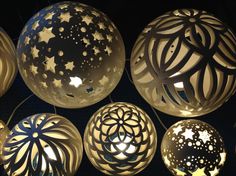 several decorative lights hanging from the ceiling in a dark room with stars and circles on them