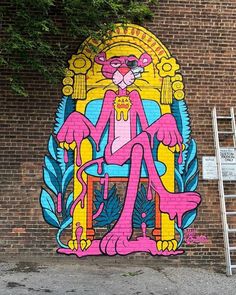 a mural on the side of a brick building depicting a cat sitting in a chair