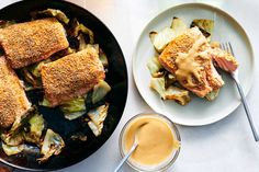 two plates with food on them next to a bowl of sauce