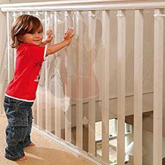 a little boy standing next to a white railing