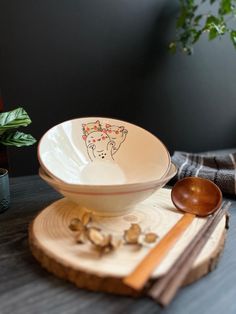 a bowl and spoon sitting on top of a wooden plate